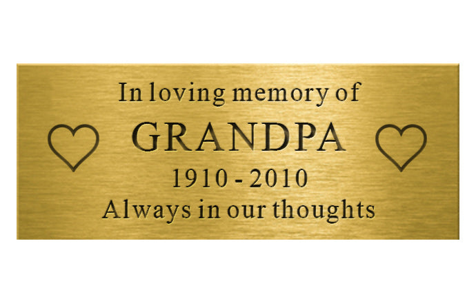 Gold plaque with engraved text 'In loving memory of GRANDPA 1910-2010 Always in our thoughts' on a white background
