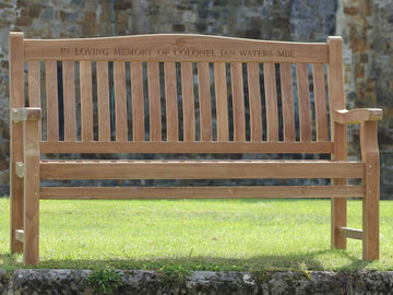 wood engraved text on a memorial bench in graveyard