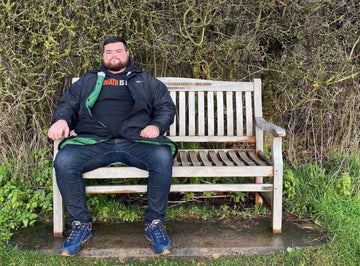 rate this bench sitting on a teak memorial bench with hedge in background