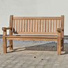 FSC 3 seat Wooden memorial garden bench on a stone patio with a white wall background