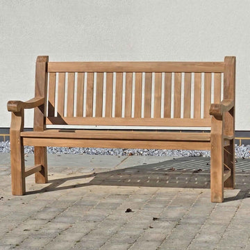 FSC 3 seat Wooden memorial garden bench on a stone patio with a white wall background