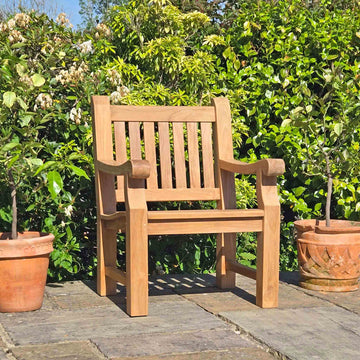 memorial armchair on a patio with greenery in the background