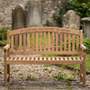 Wooden teak memorial bench with 'In Loving Memory of Mum' inscription in a cemetery.
