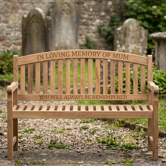 Wooden memorial bench with engraved text in a cemetery